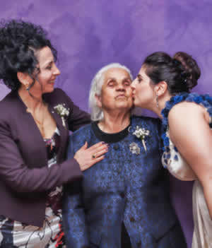Three women three generations all dressed in blue and purple.