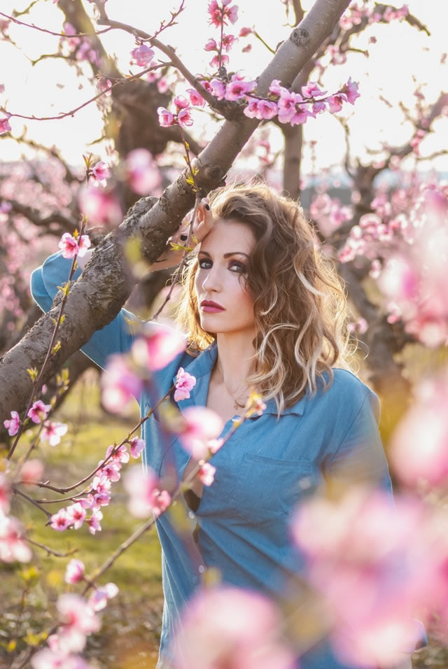 Girl holding an orange branch in a magical forest.